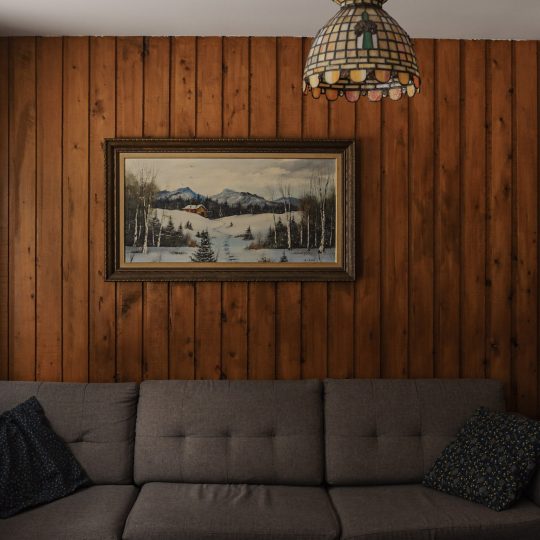 Tableau de paysage hivernal au-dessus du canapé du chalet Le Sous-bois