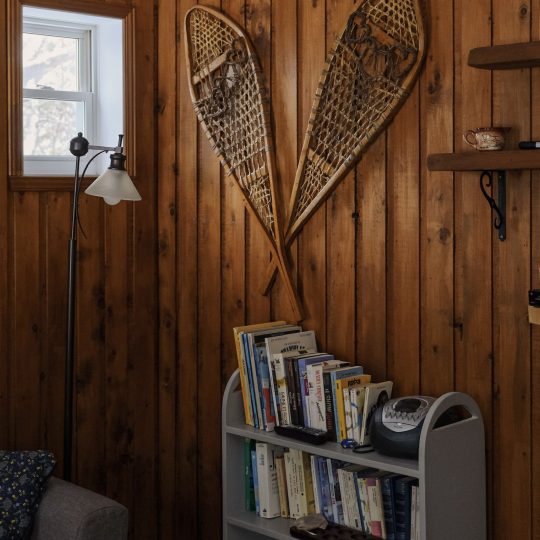 Raquettes décoratives et coin lecture dans le salon du chalet Le Sous-bois